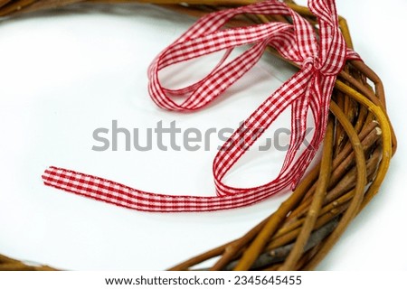 Beautiful textured Christmas wreath made from intertwined vine branches Natural white background enhances the rustic charm Selective focus emphasizes the intricate details of the wreath