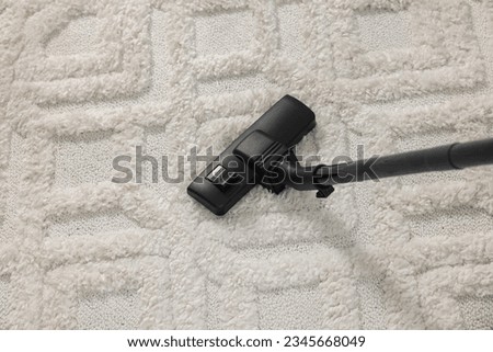 Hoovering carpet with vacuum cleaner, above view Royalty-Free Stock Photo #2345668049