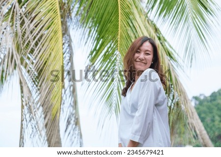 Portrait image of a beautiful young asian woman and coconut trees by the sea