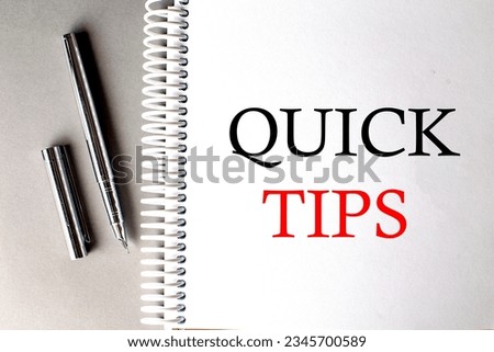 QUICK TIPS text on notebook with pen on grey background