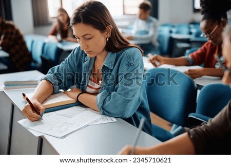 Female student learning during a class at university classroom.
