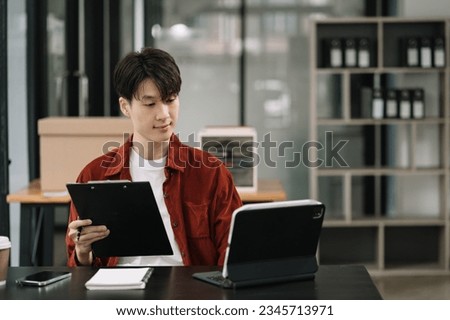 Businessman using laptop computer with documents in office. Happy man, entrepreneur, small business owner working online.