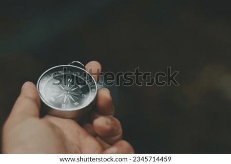 close up hand holding compass, nature copy space background for text, travel and lifestyle, planning and manage to success business wallpaper concept Royalty-Free Stock Photo #2345714459