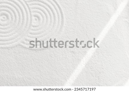 Japanese Zen Garden with concentric circles and with sunlight on white sandy texture surface background,Sand with simple spiritual patterns,Harmony,Meditation,Zen like concept