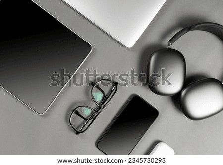 Set of modern gadgets on a beautiful dark or gray background with headphones, laptop, phone, joystick, glasses and camera
