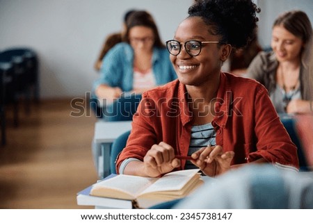 Happy African American university student learning in lecture hall. Royalty-Free Stock Photo #2345738147