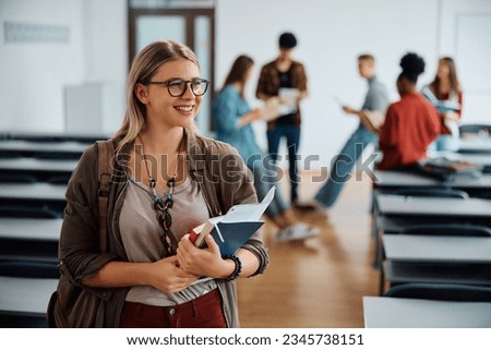 Happy female student at university classroom looking away. Royalty-Free Stock Photo #2345738151