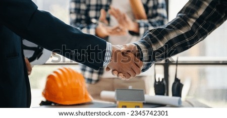 Engineer desk with object paper and tablet with blurry engineer teamwork hardworking to consults building project.
 Royalty-Free Stock Photo #2345742301