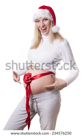 Pregnancy . Pregnant woman in santa hat . A gift for the new year . Woman with a red bow and ribbon on a big belly