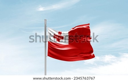 Tonga national flag waving in beautiful sky. Royalty-Free Stock Photo #2345763767