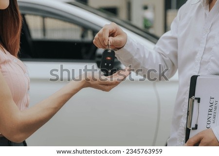 Car sales or rentals: Happy customers with car dealership agents make deals and sign contracts, agreement documents. Royalty-Free Stock Photo #2345763959