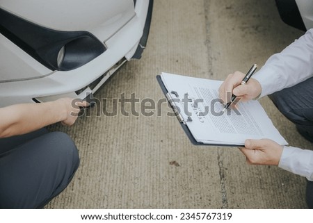 Insurance Agent examine Damaged Car and filing Report Claim Form after accident, Traffic Accident and insurance concept.