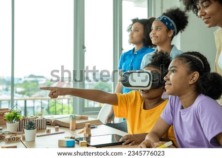 African american elementary school children gesturing while wearing vr glasses in classroom,Education,Virtual reality simulator. Royalty-Free Stock Photo #2345776023