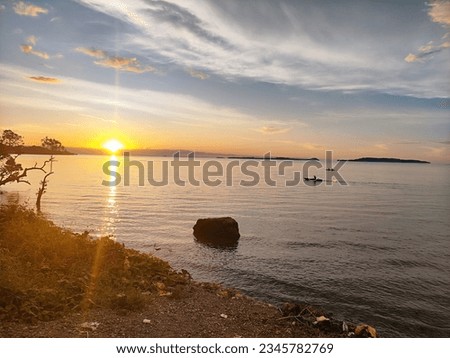 a picture of a sunset view and two fishermen fishing in the sea