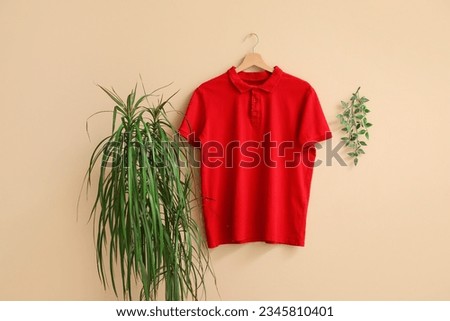 Stylish red t-shirt hanging on beige background