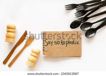 Eco friendly wooden and harmful plastic cutlery with Say no to plastic sign. Zero waste concept.