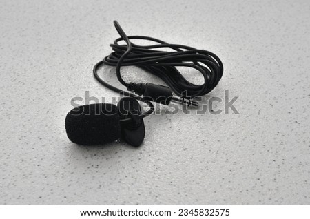 Professional lavalier microphone close-up, perfect for high-quality audio recording. Precise and professional audio recording and production concept.