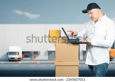 Businessman with boxes. Business man near industrial building. Businessman with laptop. Guy works in field fulfillment. Businessman near cardboard boxes. Man delivers goods to marketplace warehouse.