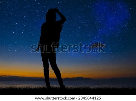 Silhouette of a woman looking at the starry sky