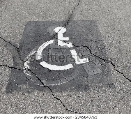 A close view of the handicap sign on the pavement.
