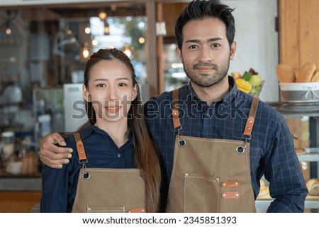 Asia couple owner happy the first day of small business cafe. guarantees safety, cleanliness, open the coffee shop. New normal. SME, welcome, restaurant, home made, family 
