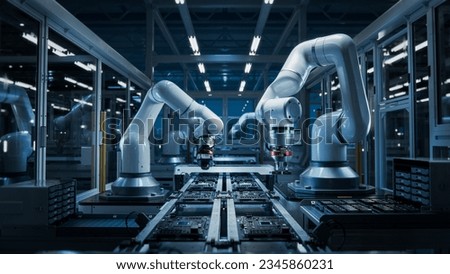 Advanced High Precision Robot Arms on Fully Automated PCB Assembly Line Inside Modern Electronics Factory. Electronic Devices Production Industry. Component Installation on Circuit Board Royalty-Free Stock Photo #2345860231