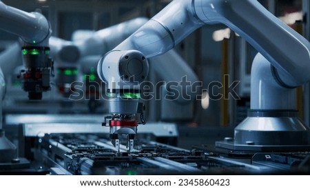 Advanced High Precision Robot Arm inside Electronics Factory. Component Installation on Black Circuit Board. Electronic Devices Production Industry. Fully Automated Modern PCB Assembly Line.