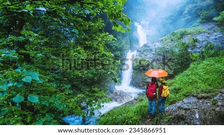 Lover asian man and asian women travel nature Travel the highest waterfall in Chiangmai Mae-pan waterfall rainy season at Doi intanon. Royalty-Free Stock Photo #2345866951