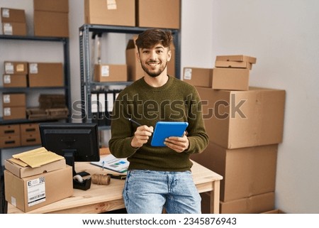 Young arab man ecommerce business worker using touchpad at office Royalty-Free Stock Photo #2345876943