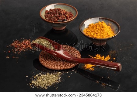 Variety of spices on a dark background in a glass bowl. Enhancement of taste. copy space