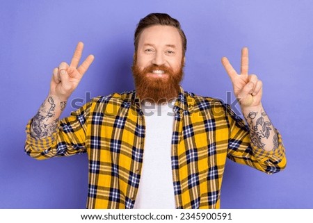Photo of funny cheery guy overjoyed good mood showing v sign symbols hands toothy smiling isolated purple color background