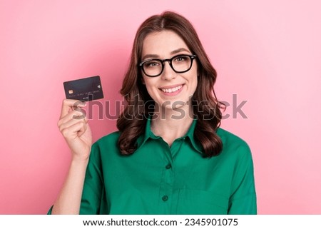 Photo of pretty shiny lady wear green shirt eyeglasses smiling rising bank card isolated pink color background