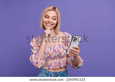 Photo of cheerful thoughtful lady wear flower print crop top reading news modern gadget isolated violet color background