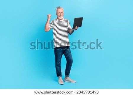 Photo of cheerful funny man wear trendy clothes raise hand fist rejoice buy netbook special price sale isolated on blue color background