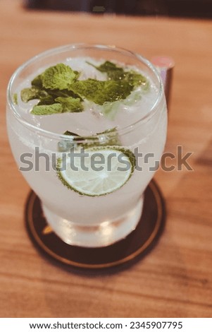 Mojito soda drink with lime and mint leaves on top.