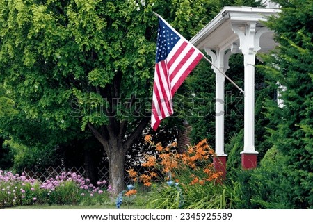 A patriotic summer scene and a beautiful front yard garden in Manitowoc, Wisconsin. Royalty-Free Stock Photo #2345925589