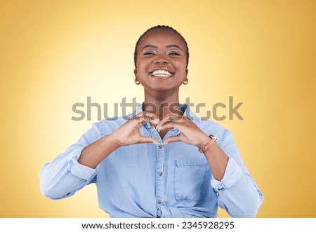 Portrait, heart hands and black woman, smile and studio isolated on yellow background. Face, love sign and happy African person in kindness, care and empathy, support and trust, romance or solidarity Royalty-Free Stock Photo #2345928295
