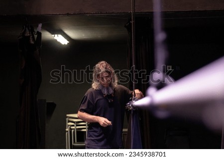 theatre technician setting up the curtain