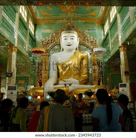 Crowd of faithful before golden Buddha in pagoda, Sagaing, Myanmar. High quality photo