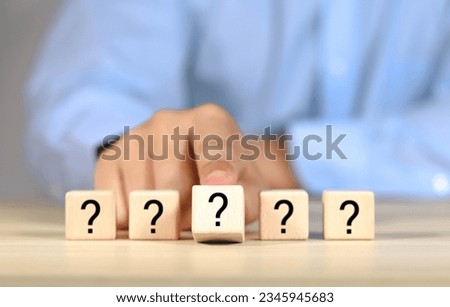 Question mark, Confused, Thinking, Brainstorming or Decision, Problem Solving, Finding Answer, Question. Marked words in wooden blocks on table top.