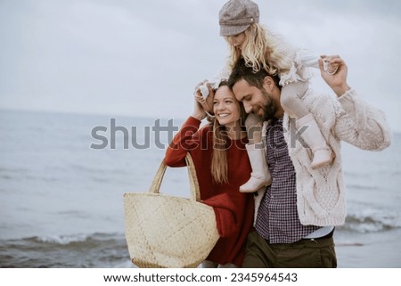 Young family walking on a beach during winter