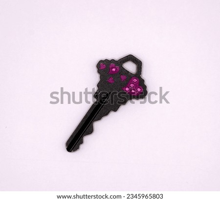 Black key with pink hearts on it on a white background