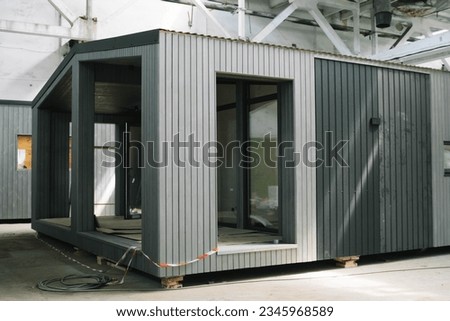 A new wooden modular prefabricated house inside an industrial building Royalty-Free Stock Photo #2345968589