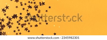 Banner with gold colored stars confetti on a yellow background. Place for your design. Royalty-Free Stock Photo #2345982301
