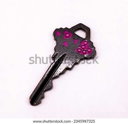 Black key with pink hearts on a white background
