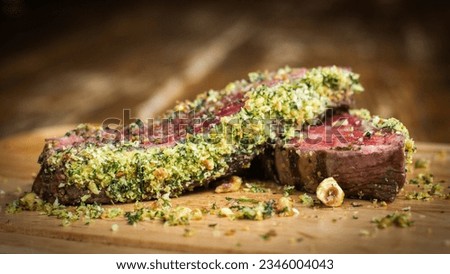 Flank Steak with hazelnut and herb crust on wooden board in a restaurant Royalty-Free Stock Photo #2346004043
