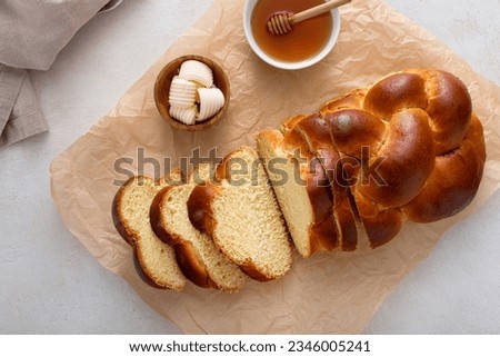Freshly baked hallah sliced served with butter and honey, overhead shot Royalty-Free Stock Photo #2346005241