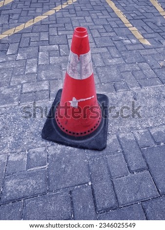 an orange traffic cone at the parking lot