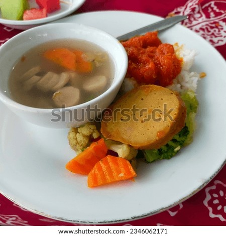 A picture of a rice, vegetable, soup on the table dinning