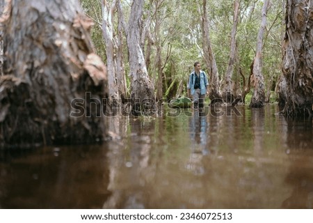 Asian man traveling alone in the mangrove forest Asian rivers and forests.